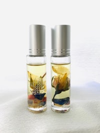 two bottles of oil with flowers in them